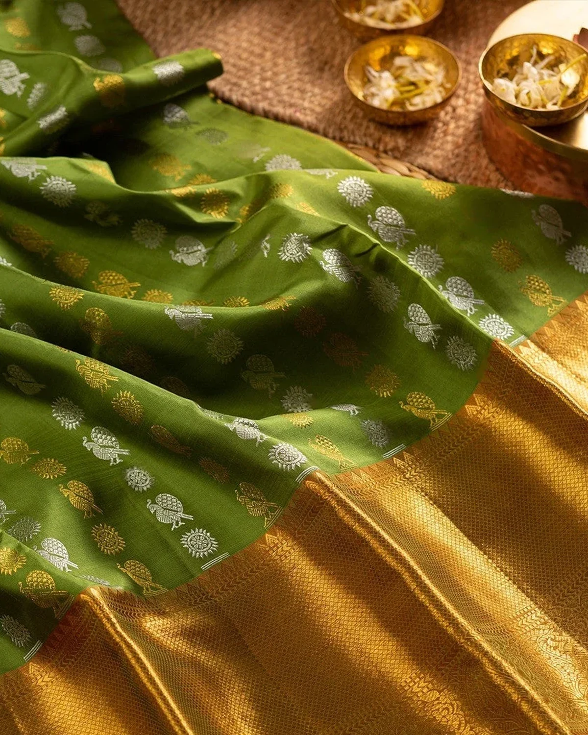 Green silk saree with evenly spaced gold and silver butta motifs and a broad zari border
